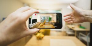A smartphone on a table in a modern living room representing smart home technology.