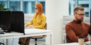 A professional working at a desk in a bright, modern office.