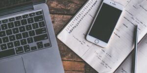 A smartphone and planner on a desk representing organized co-parenting.